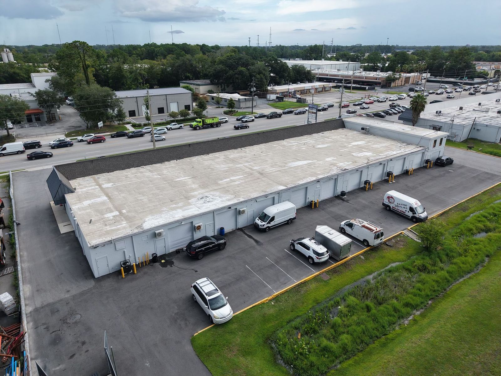 Rear service drive at Andson Plaza with grade-level roll-up doors and tenant service vans